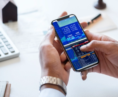 Persona revisando una aplicación de trading en el móvil, concepto de aplicaciones falsas de inversión