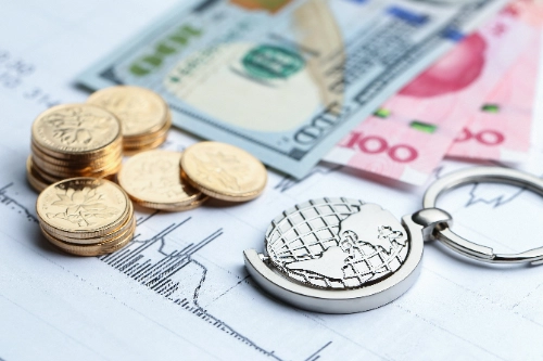 Monedas, billetes y un globo terráqueo sobre fondo de estadísticas